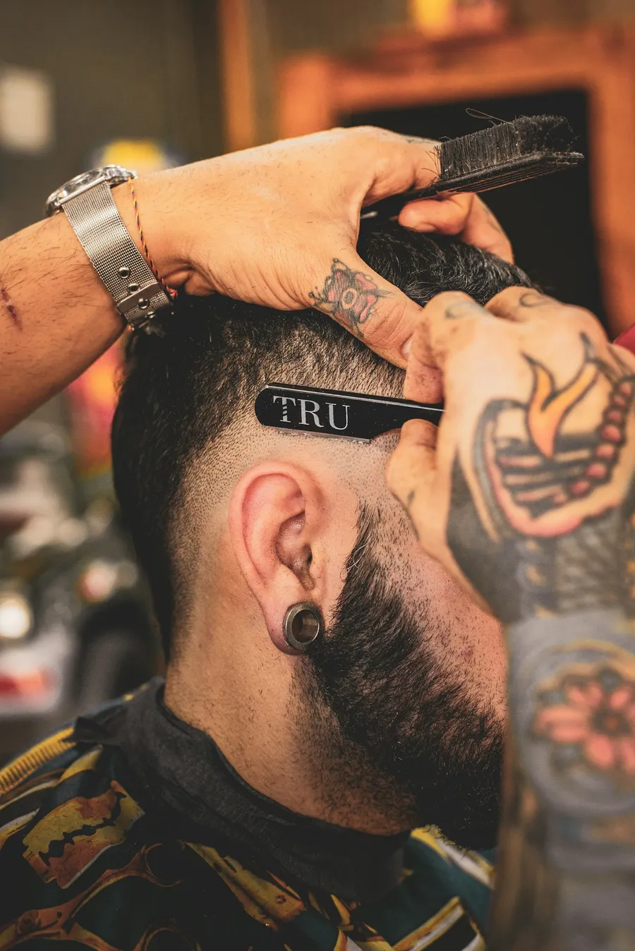 The storefront of a classic neighborhood barbershop with a vintage barber pole.